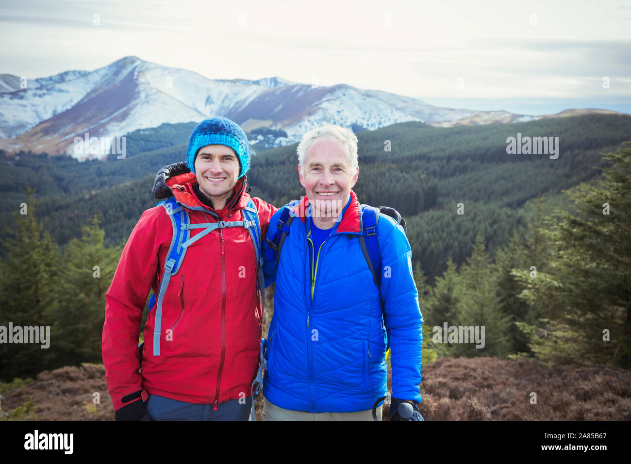 Portrait happy father and son hiking with scenic mountains in background, Lake District, UK Stock Photo
