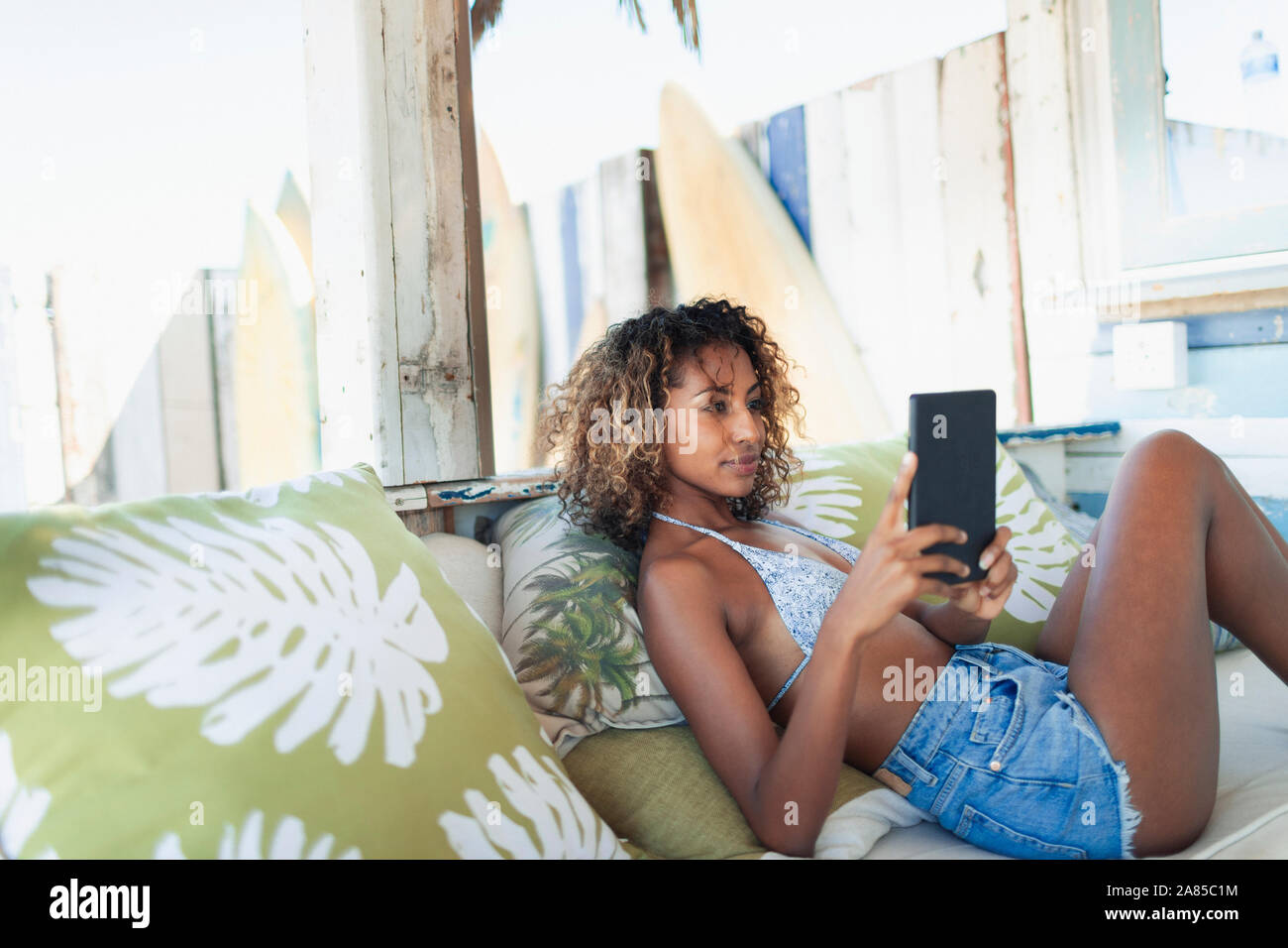 Young woman using digital tablet on beach patio Stock Photo