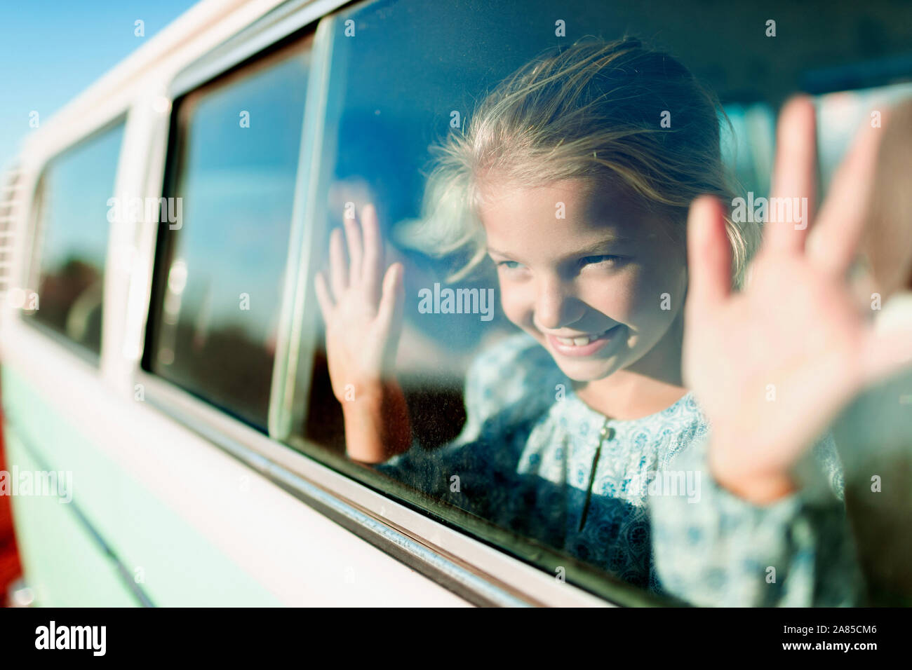 Happy, carefree girl riding in sunny van Stock Photo