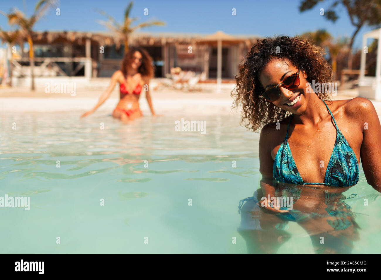 Portrait confident young woman in bikini swimming in sunny ocean Stock Photo