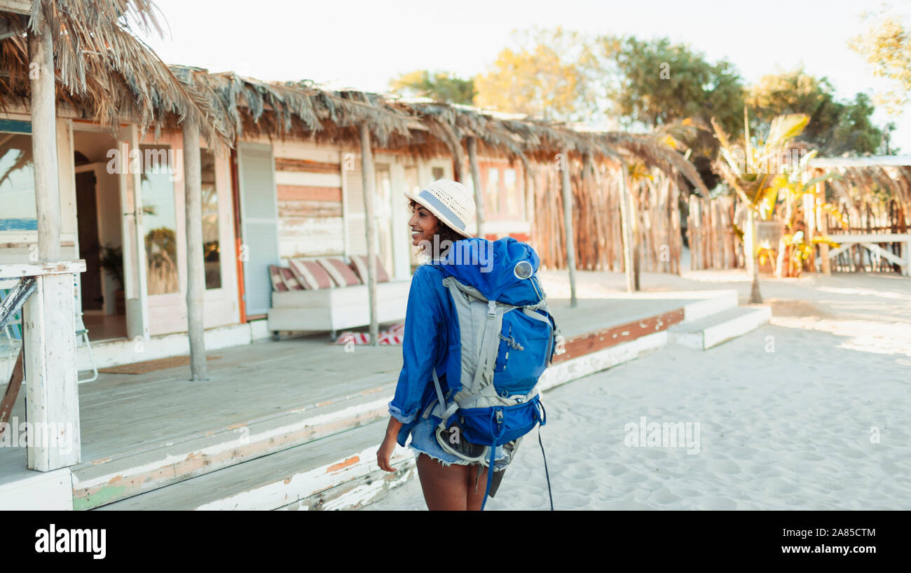 Young female backpacker arriving at beach hut Stock Photo