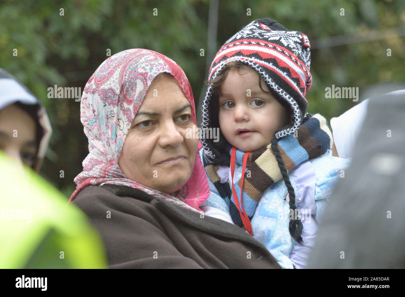 An Iraqi refugee woman holds her 18-month old daughter, Mahdi, as they approach the border into Croatia near the Serbian village of Berkasovo. Stock Photo