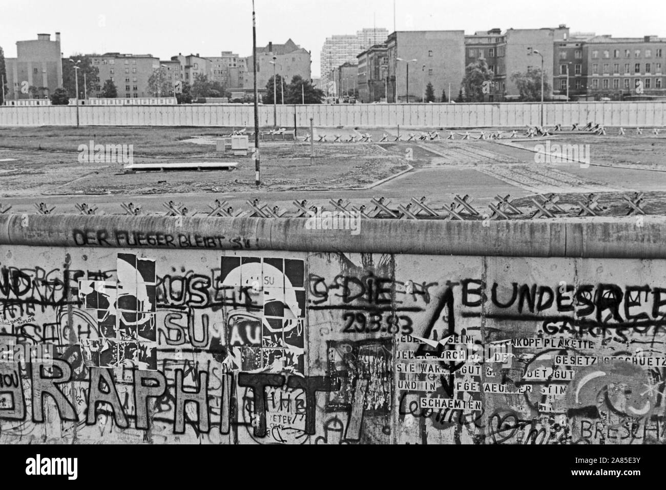 Graffiti an der Berliner Mauer mit Blick in den Ostteil der Stadt, Deutschland 1984. The Berlin wall decorated with graffiti and a view to the Eastern part of the city, Germany 1984. Stock Photo