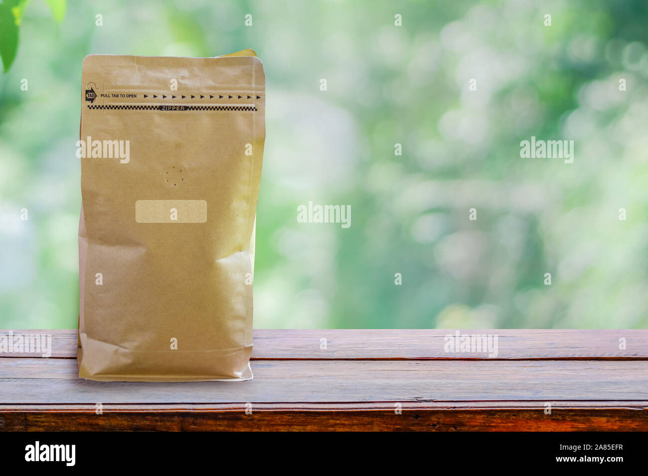 Paper packaging smelling hole, Coffee bean packaging smell the flavor of coffee wafting on wooden table with Clipping path on paper bag and label Stock Photo