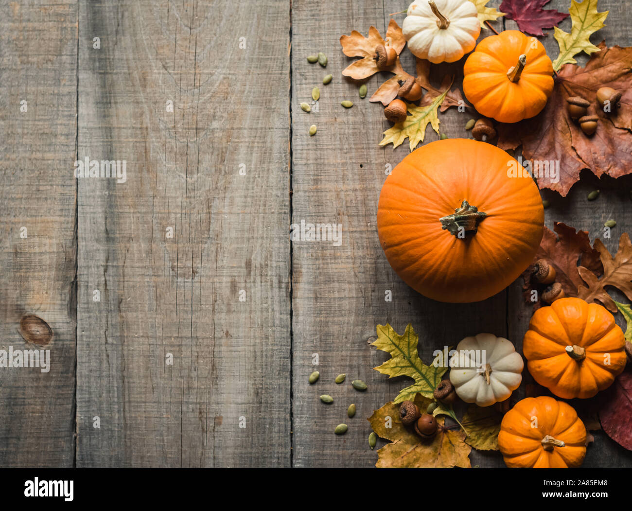 Overhead view of pumpkins and other fall decor on rustic wooden table. Stock Photo