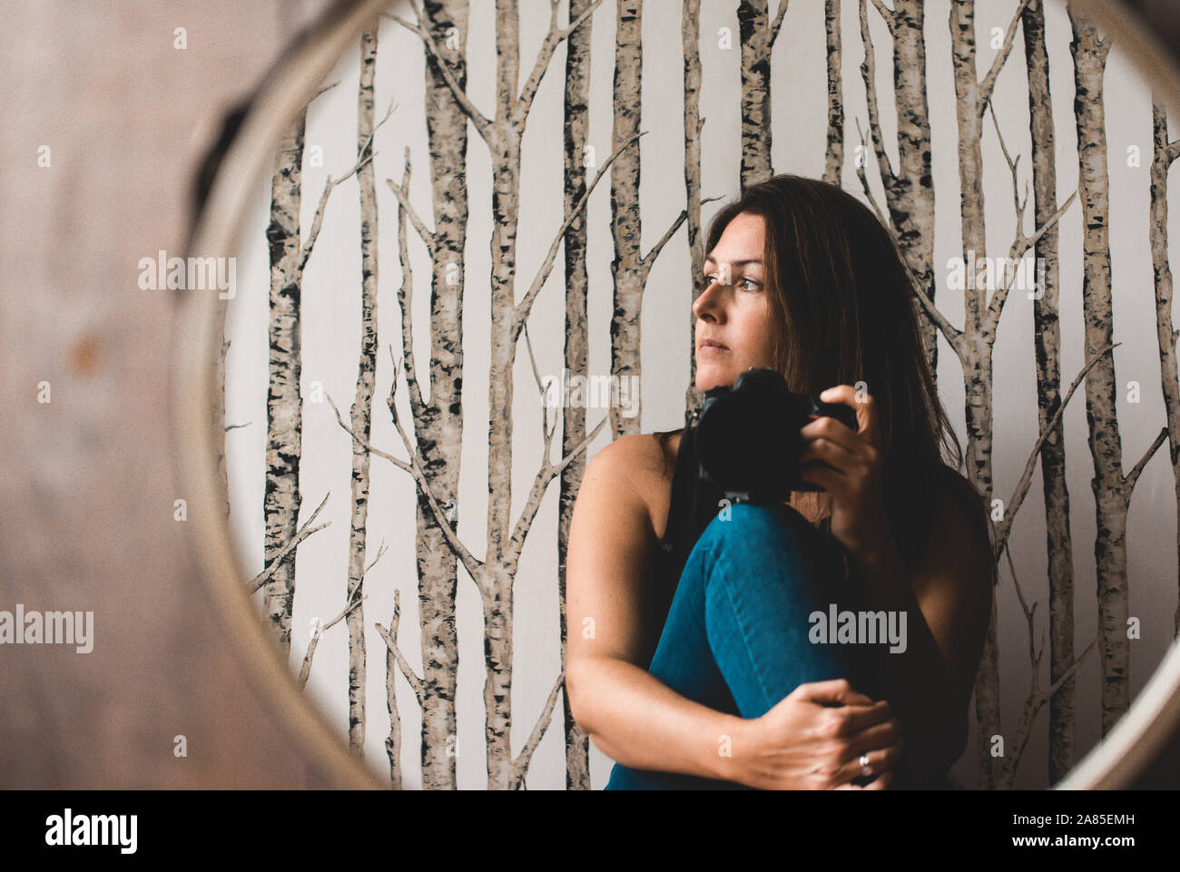 Woman holding camera taking photo of her reflection in the mirror. Stock Photo