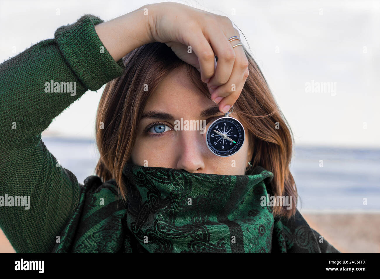 Portrait of a young woman with blue eyes. She is holding a compass Stock Photo