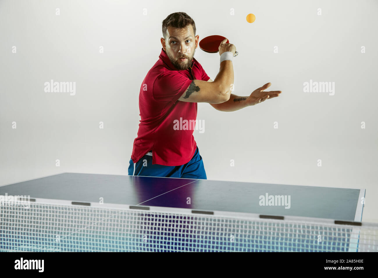 Overcoming. Young man plays table tennis on white studio background. Model  plays ping pong. Concept of leisure activity, sport, human emotions in  gameplay, healthy lifestyle, motion, action, movement Stock Photo - Alamy