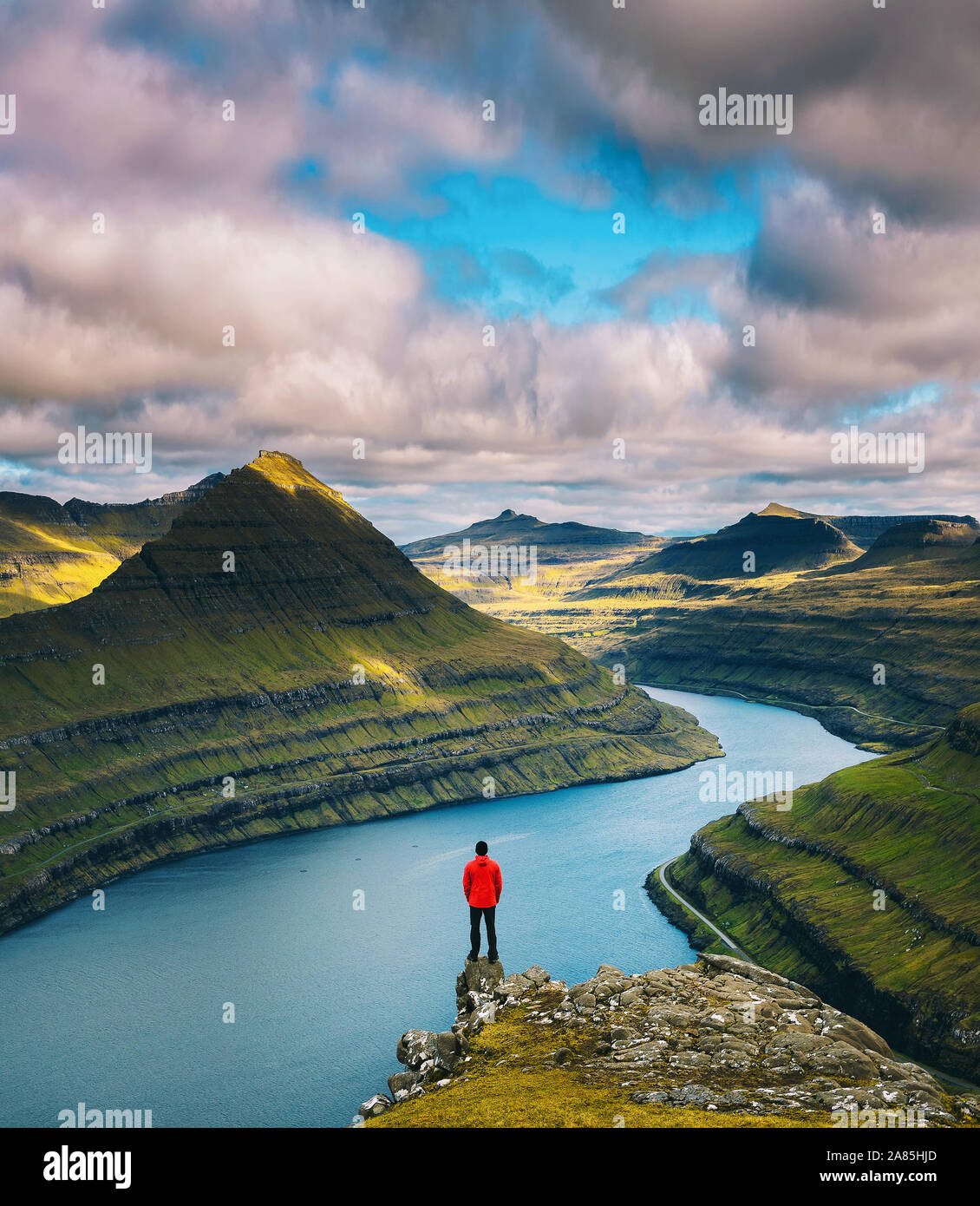 Hiker enjoys views over fjords from a mountain near Funningur on Faroe Islands Stock Photo