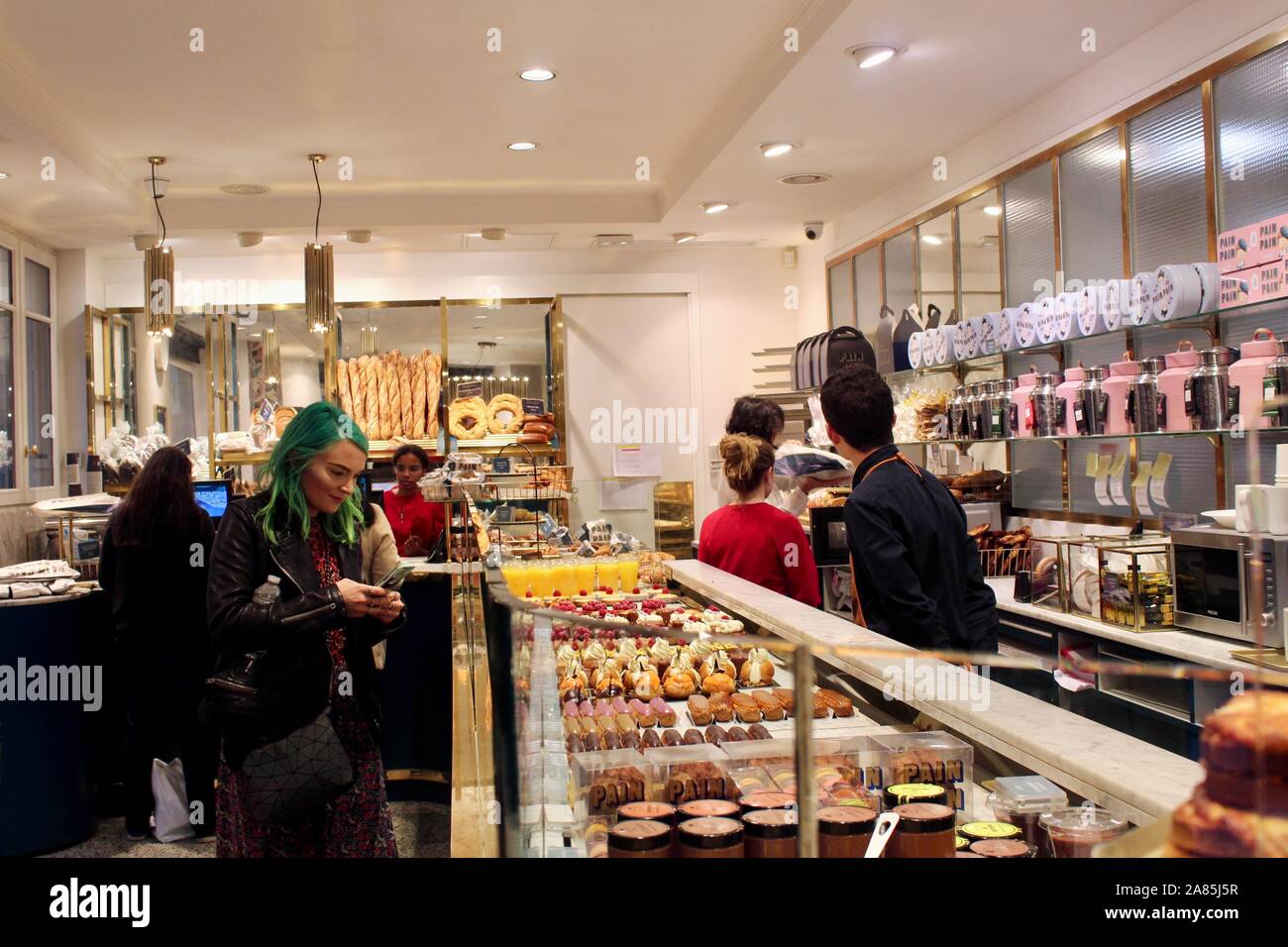 a woman with dyed green hair in parisien cake bread and pastries shop pigalle france Stock Photo