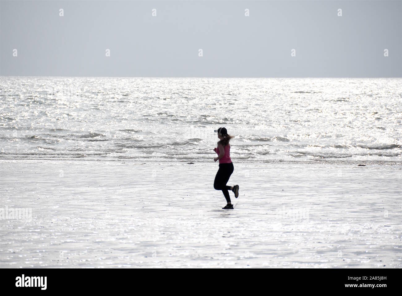 Woman running on beach Stock Photo