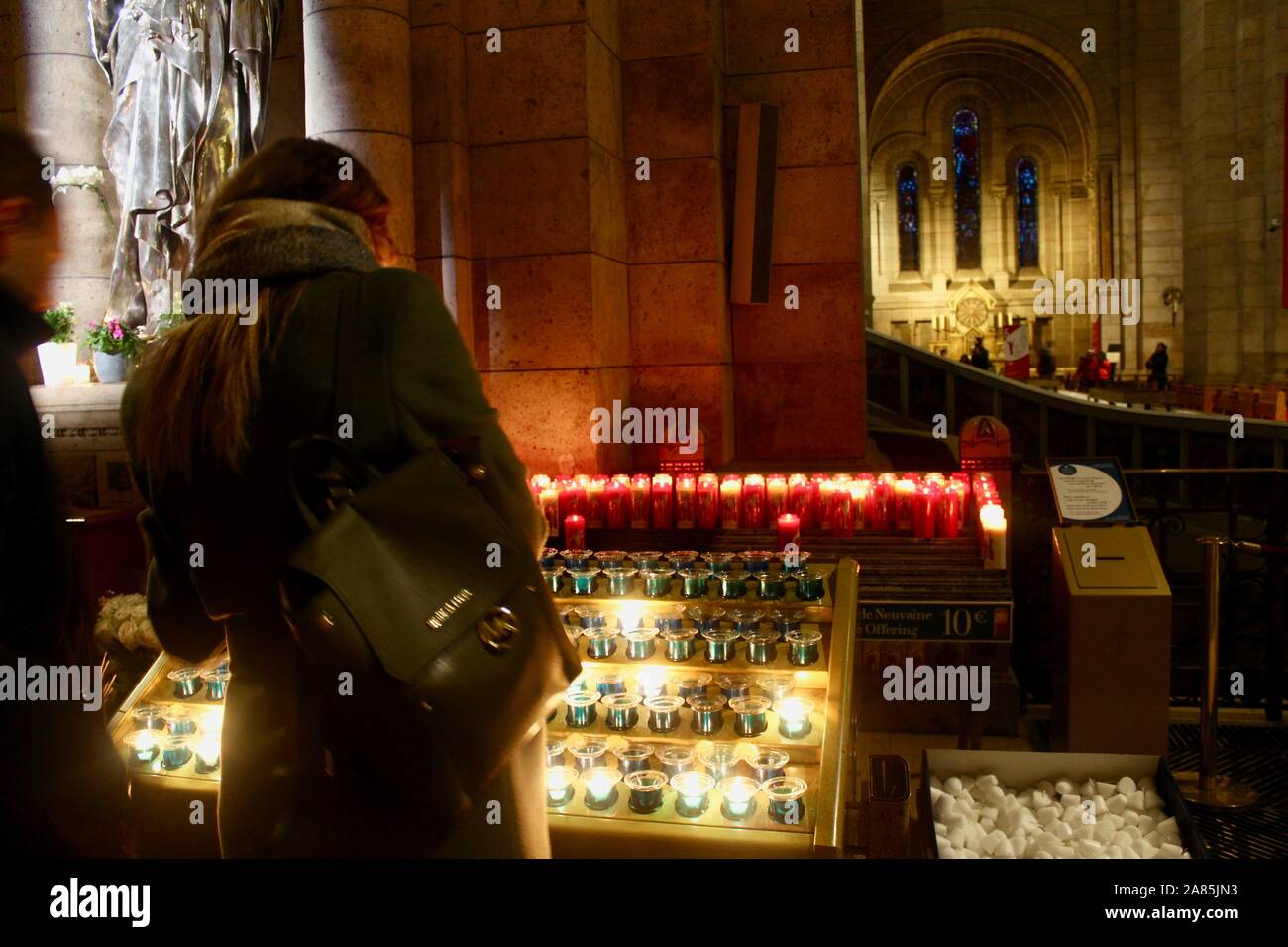 woman lighting candles in the sacre coeur paris france Stock Photo Alamy