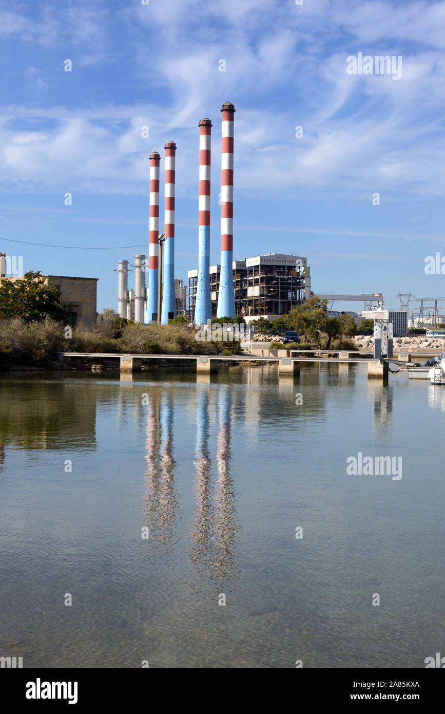 Tall Chimneys of the EDF (or Electricité de France) Thermal Power Station at Ponteau Reflected in the Anse de Laurons Bay Martigues Provence France Stock Photo