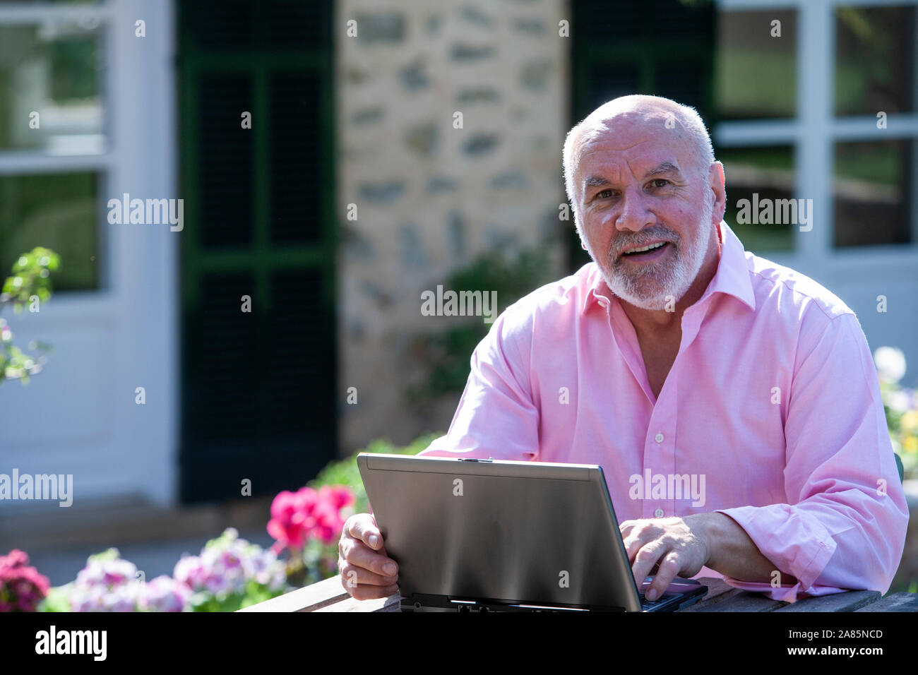 Senior man working outdoors on a laptop Stock Photo