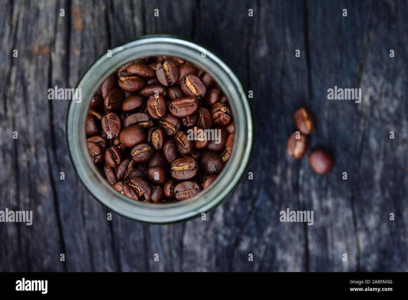 roasted coffee beans in glass containers on old wood table background, overhead view with copy space Stock Photo