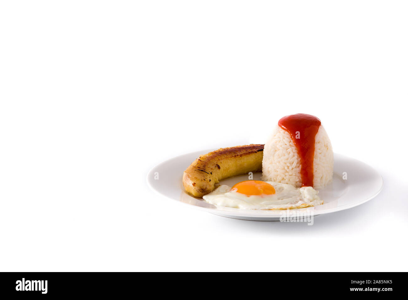Arroz a la cubana.Typical Cuban rice with fried banana and fried egg on a plate. Copy space Stock Photo