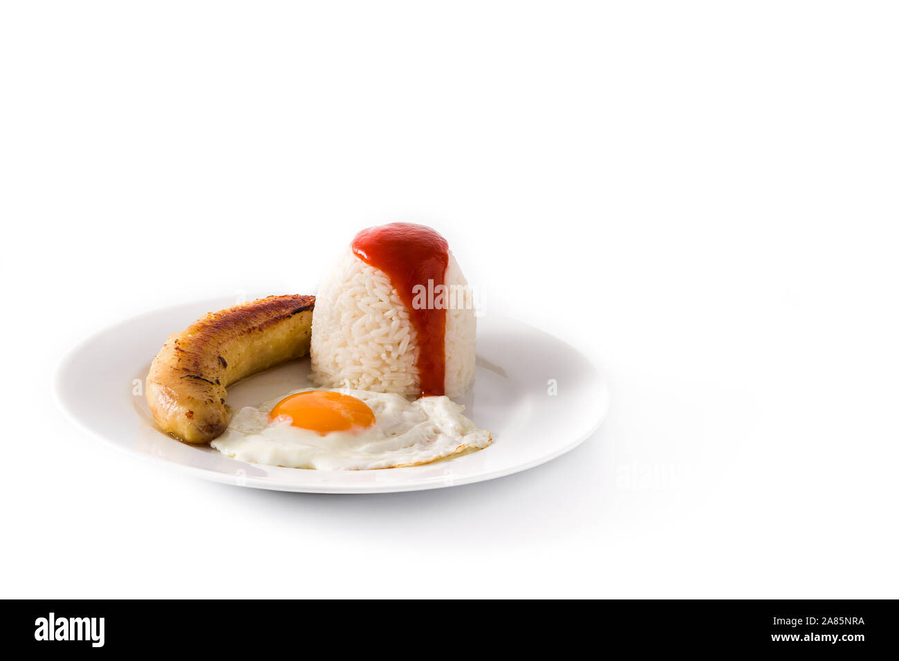Arroz a la cubana.Typical Cuban rice with fried banana and fried egg on a plate. Copy space Stock Photo