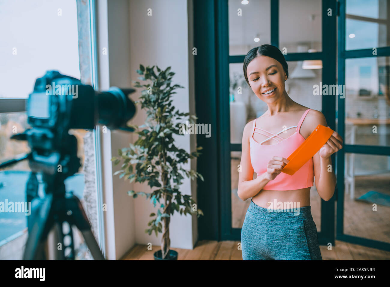 Smiling fitness blogger recommending nice resistance band Stock Photo