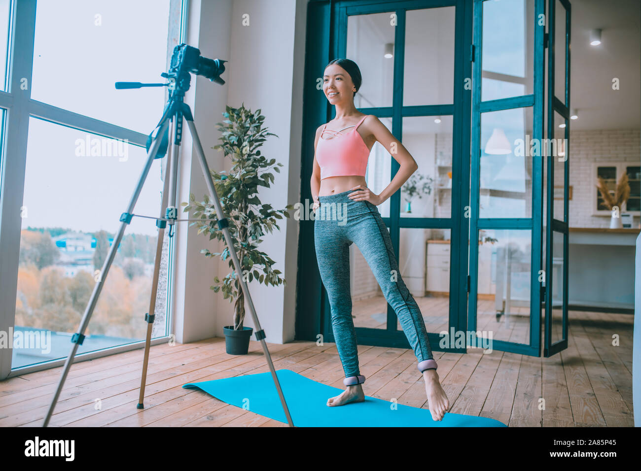 Fitness trainer wearing ankle weights and filming tutorial Stock Photo