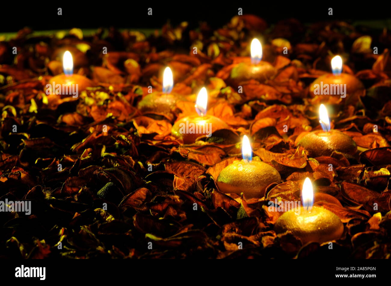 Lighted Golden Candles and ornaments of leave shallow depth of field