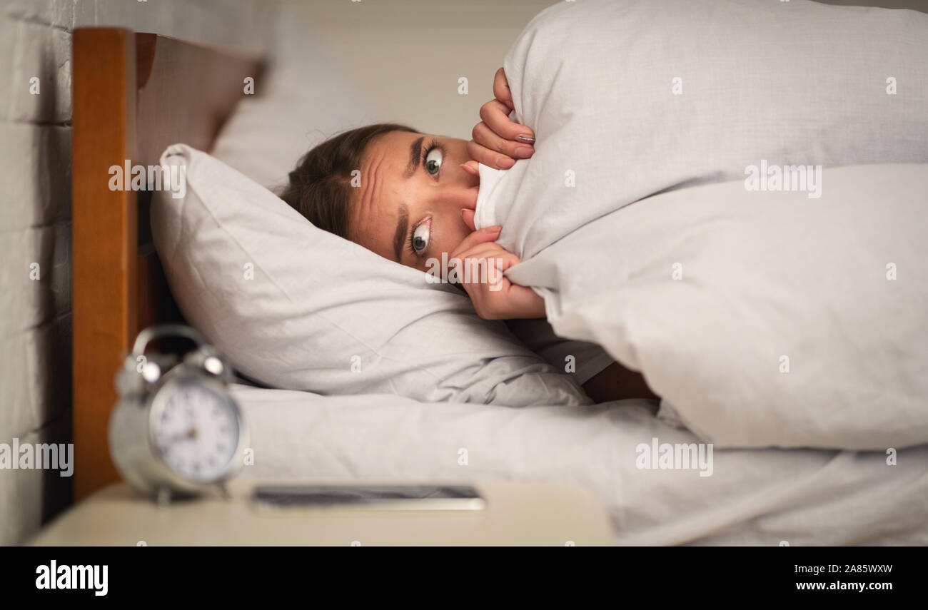 Scared Woman Pulling Blanket Over Face Lying In Bedroom Stock Photo Alamy
