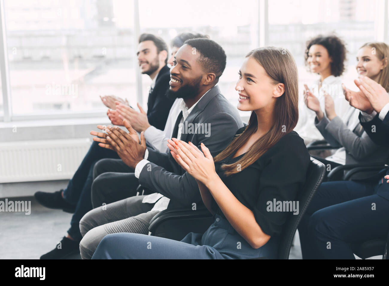 Diverse business team greeting speaker with applause Stock Photo