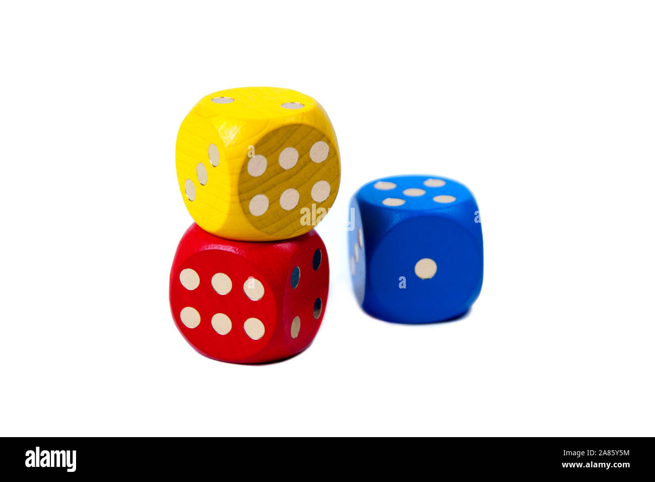 Three colorful game dice stacked, two of them showing six and one