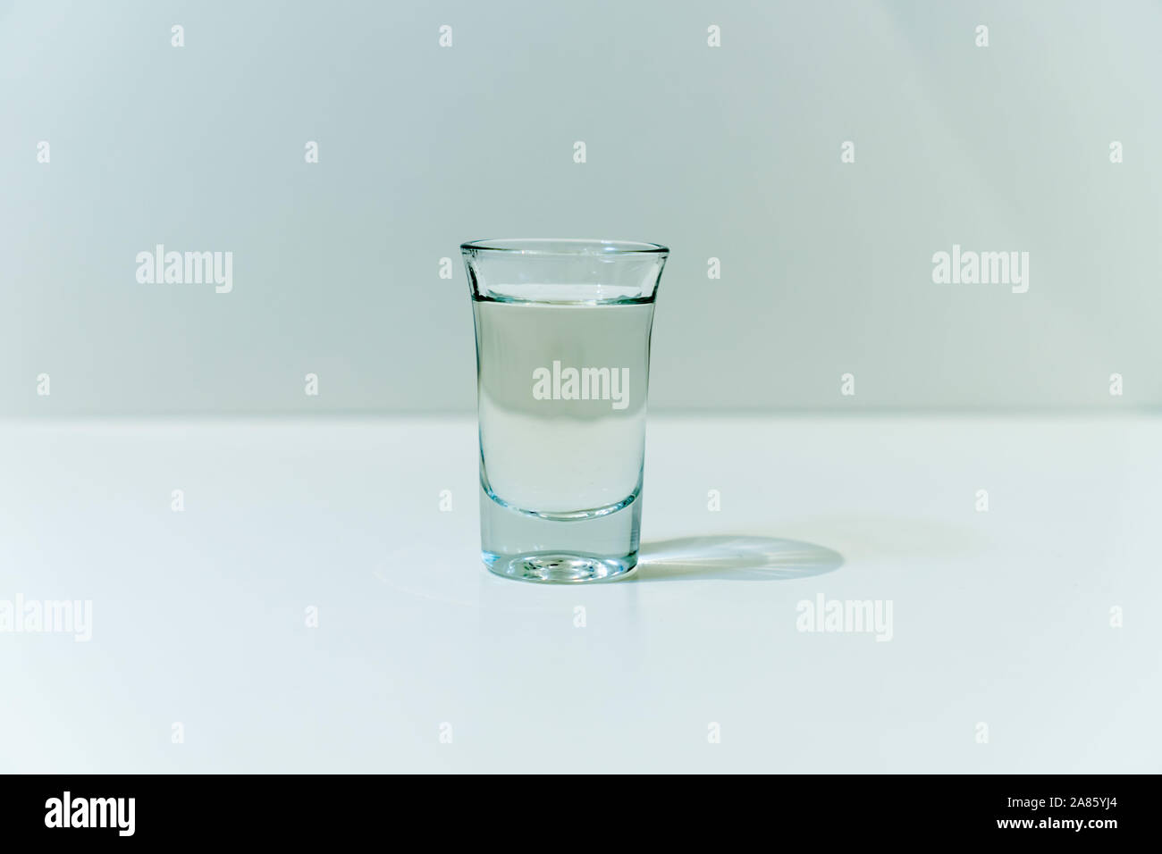 Shot fills with vodka on white table Stock Photo