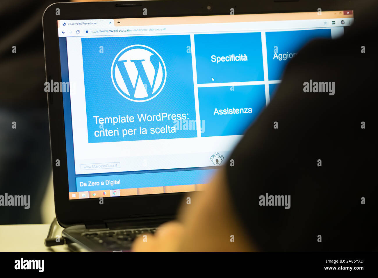 A laptop screen photographed with the Wordpress logo, partially visible from the operator's shoulders. Stock Photo