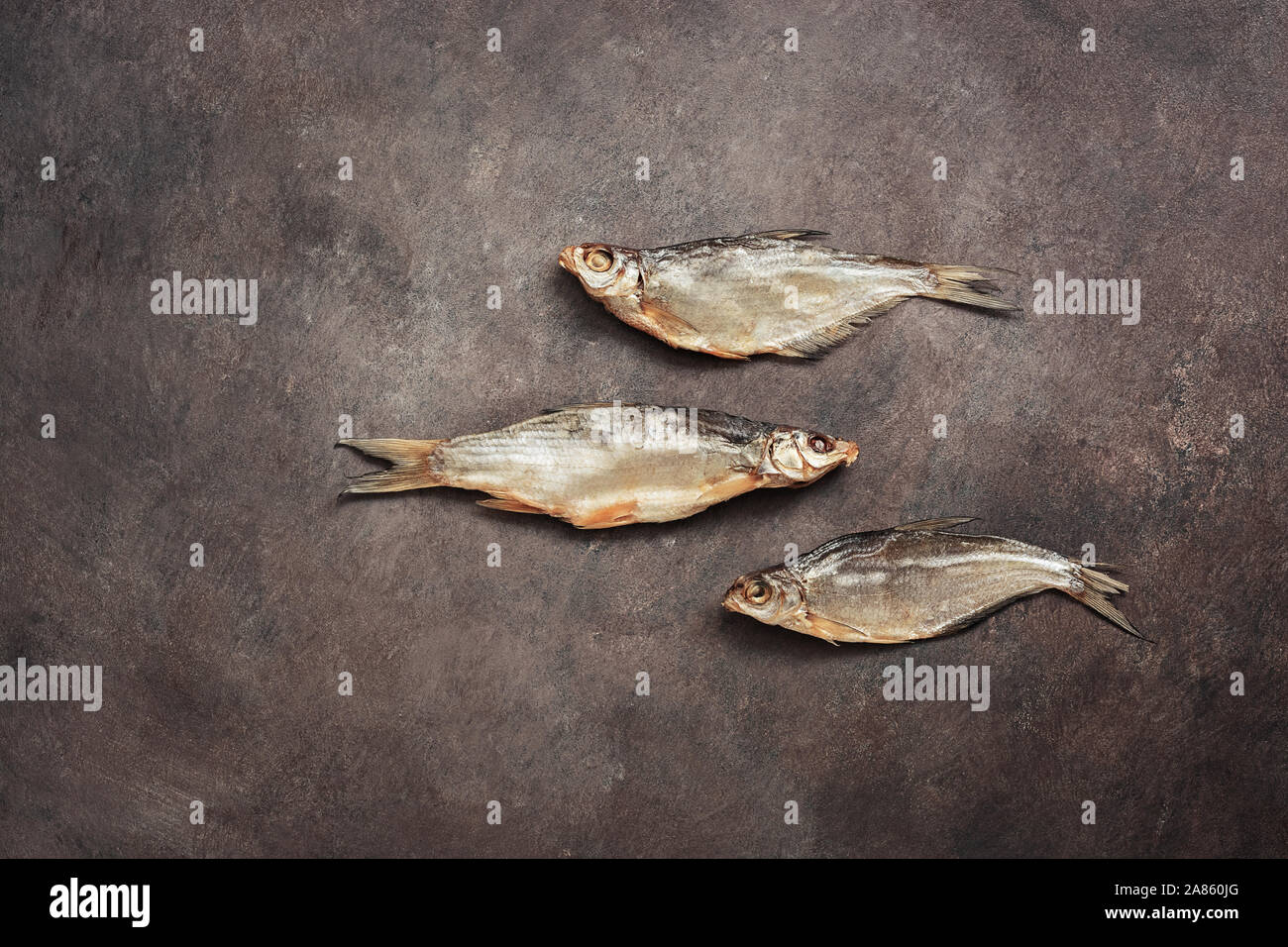 Dried fish on a dark rustic background, flat lay. Dry salted fish, top