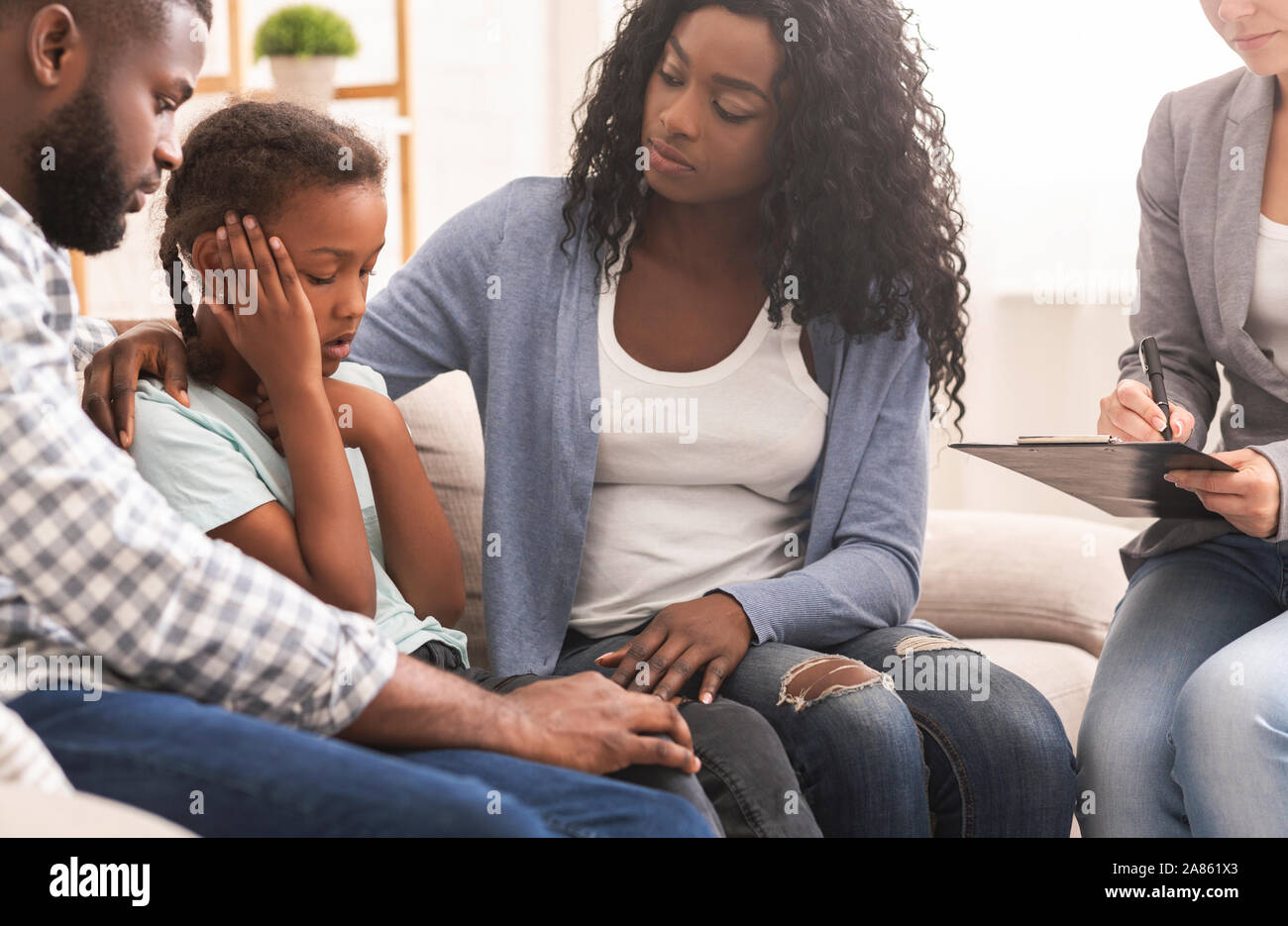 Little black girl and her parents at psychologist consultation Stock ...