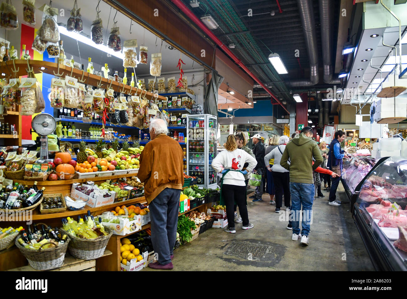 Central Market of San Lorenzo in the city center of Florence with customers buying fresh food at counters of grocery and butchery, Tuscany, Italy Stock Photo