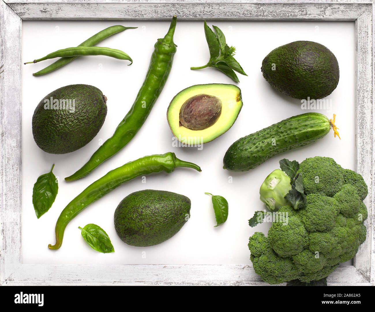 Green organic vegetables inside wooden border on white Stock Photo - Alamy