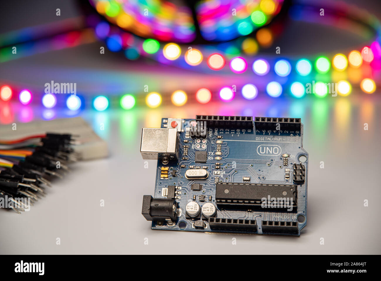 Arduino Uno displayed with LED strip, bread board, and jumper wires. Stock Photo