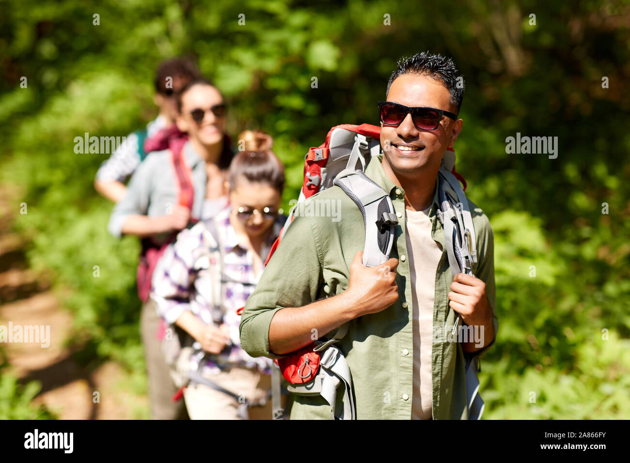 group of friends with backpacks hiking in forest Stock Photo - Alamy