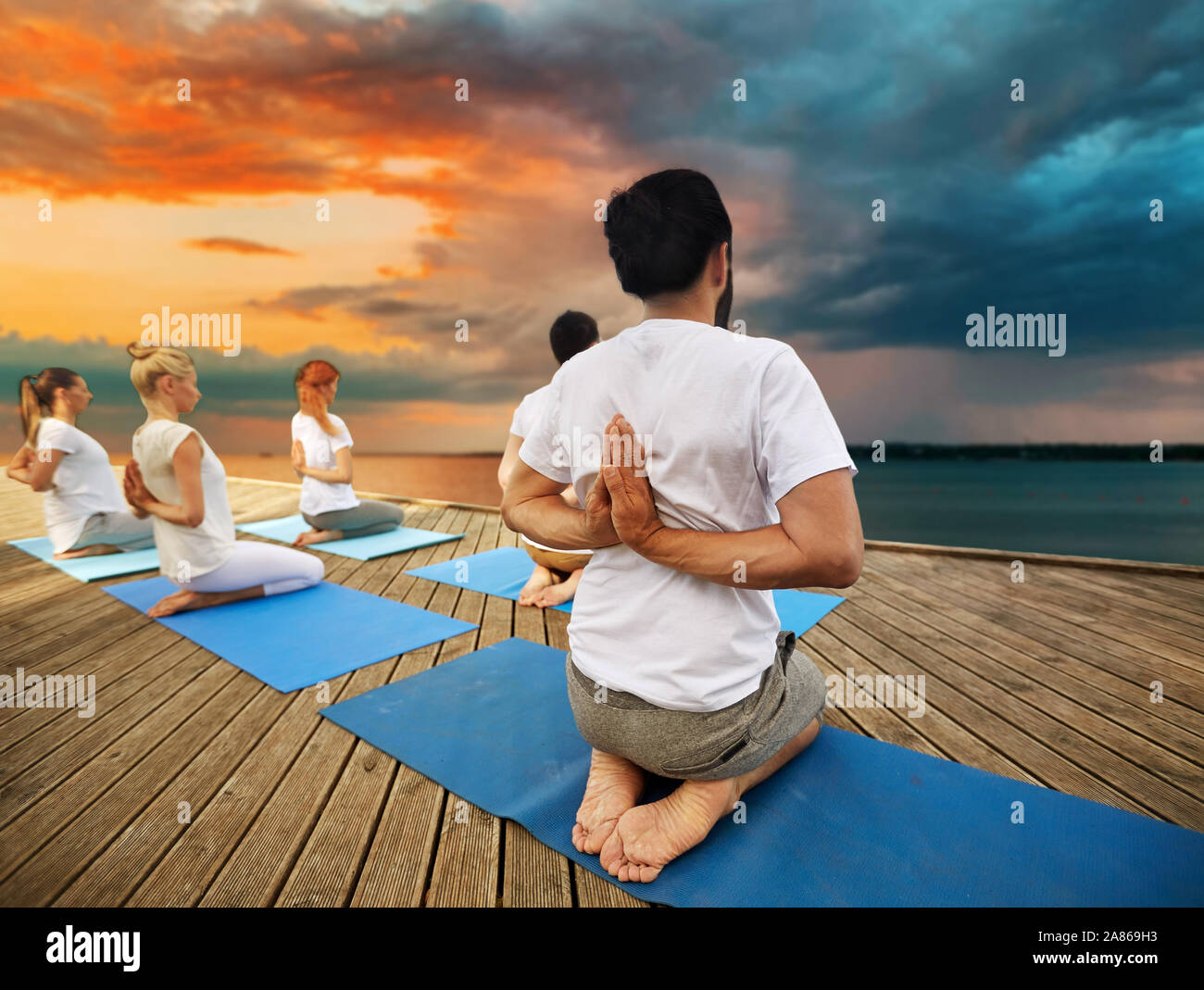 group of people making yoga exercises outdoors Stock Photo