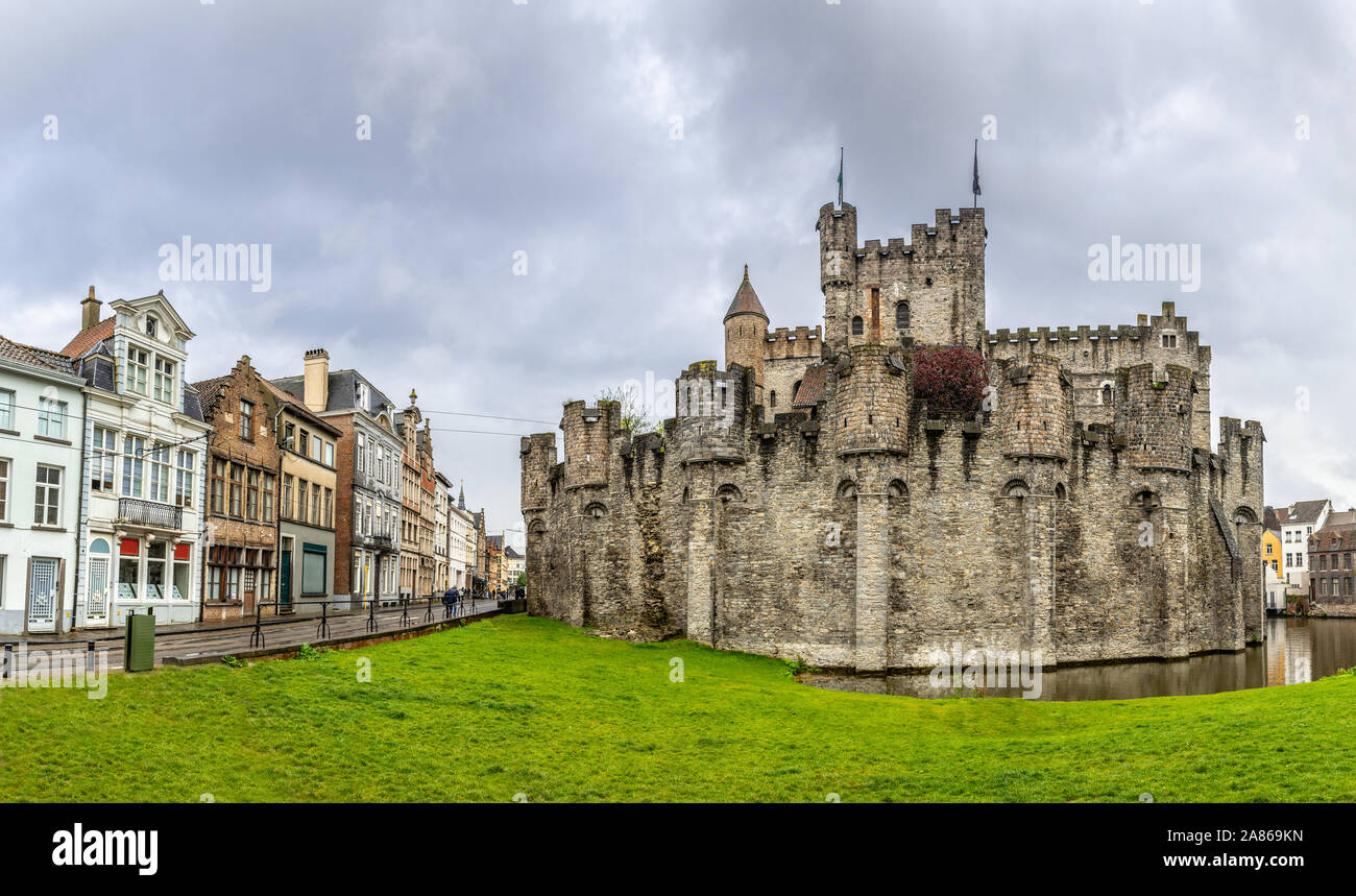 Fortified walls and towers of Gravensteen medieval castle with moat in the foreground, Ghent East Flanders, Belgium Stock Photo