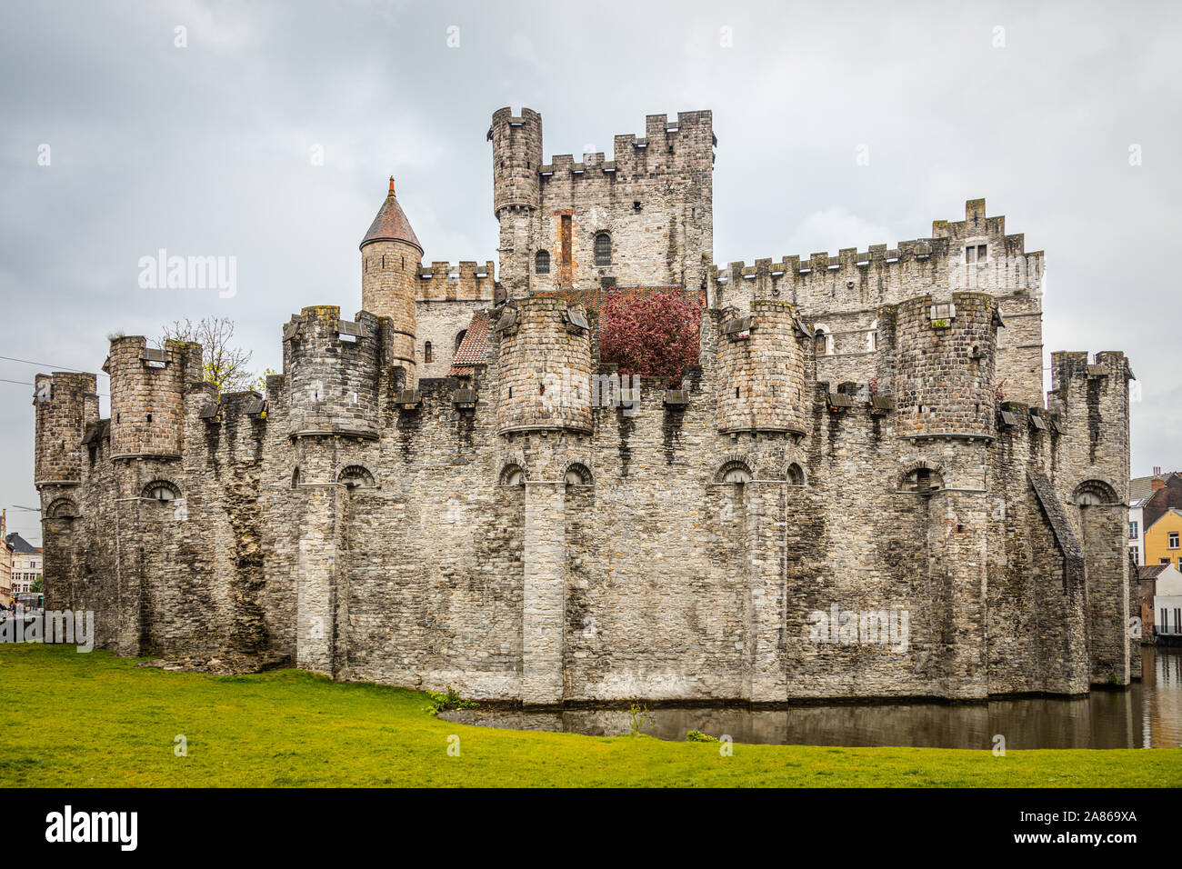 Fortified walls and towers of Gravensteen medieval castle with moat in the foreground, Ghent East Flanders, Belgium Stock Photo