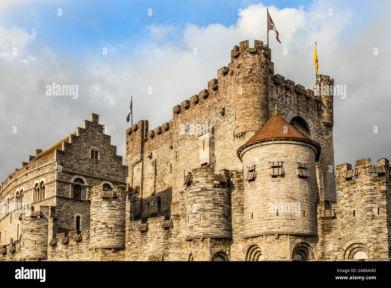 Fortified walls and towers of Gravensteen medieval castle with moat in the foreground, Ghent East Flanders, Belgium Stock Photo