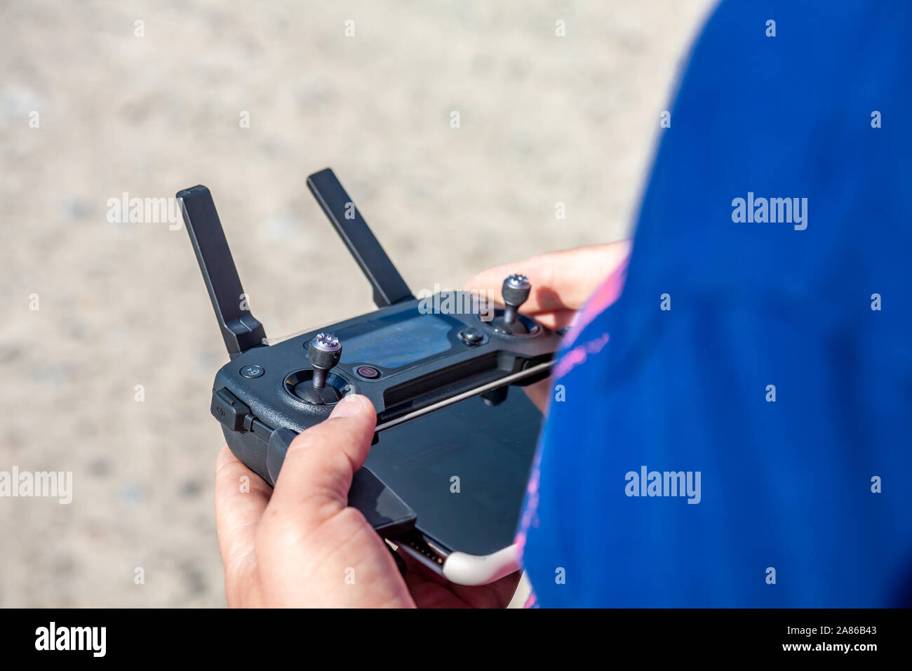 Man flying his drone by using a remote controller on the beach. Stock Photo