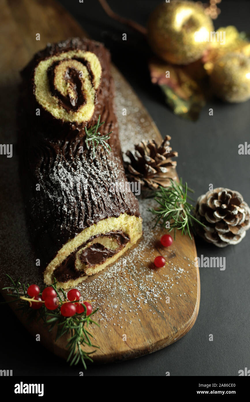 Chocolate Christmas Yule Log, Buche de Noel on wooden cutting board