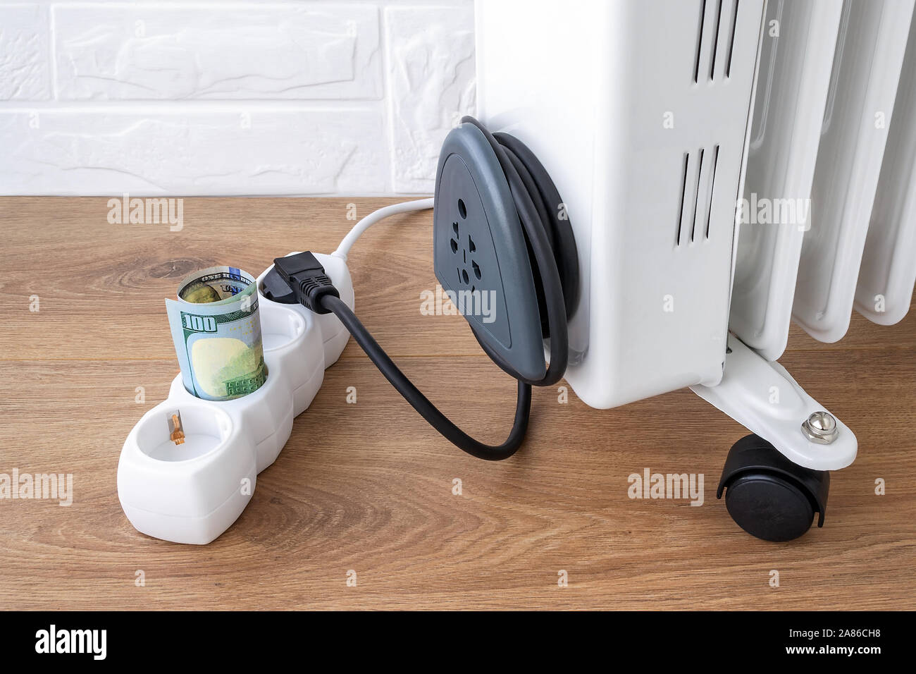 One Hundred Dollar Bill In Extension Cord Near Electric Oil Heater Plug Expensive Electricity And Higher Electricity Costs During Winter Concept Stock Photo Alamy