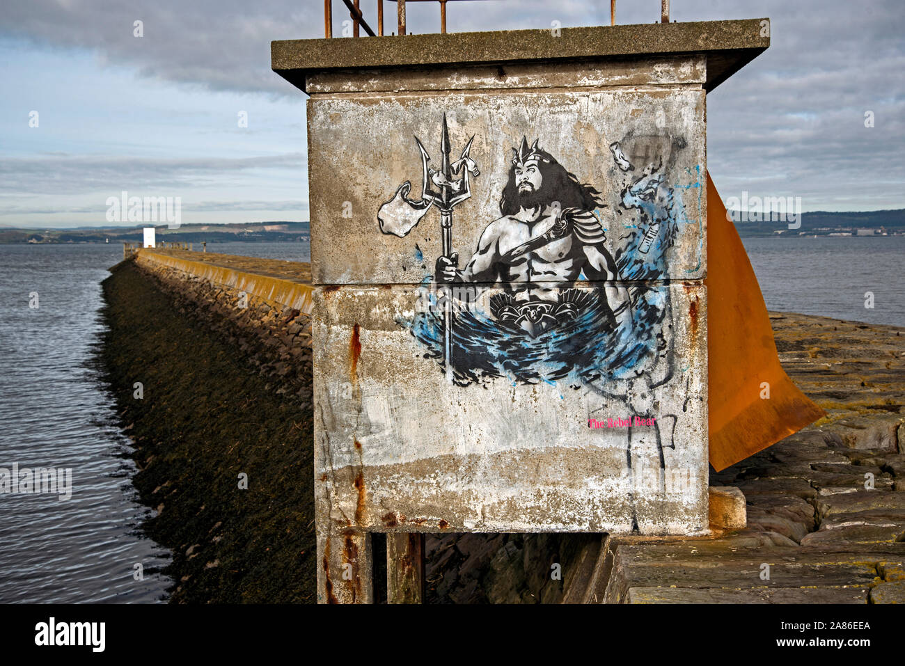 Stencil graffiti showing Neptune with plastic bags caught on his trident, on the breakwater at Granton Harbour, Edinburgh, Scotland, UK. Stock Photo