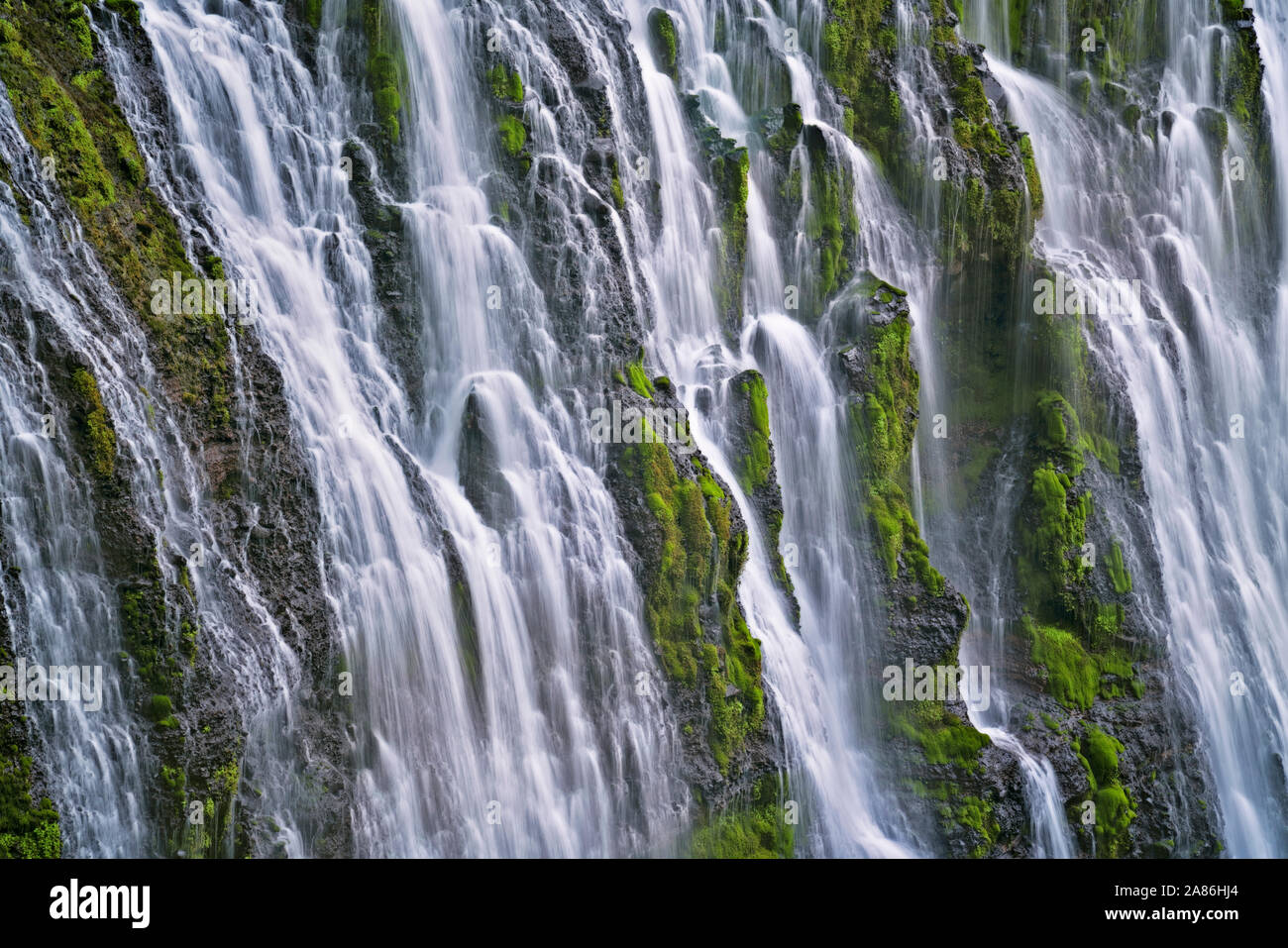 Burney Falls cascades 129 feet over moss covered basalt at northern California’s McArthur-Burney Falls Memorial State Park in the Cascade Mountain Ran Stock Photo