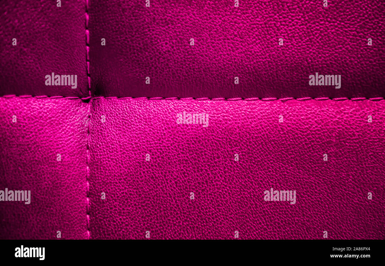 Bright electric pink textured artificial leather stitched with same color thread. Close-up of sofa surface. View from above. Highly detailed backgroun Stock Photo