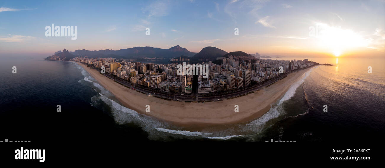 Empty Ipanema and Leblon beach at sunrise with the iconic Rio de Janeiro skyline with the Two Brothers, Corcovado and Sugarloaf mountains Stock Photo