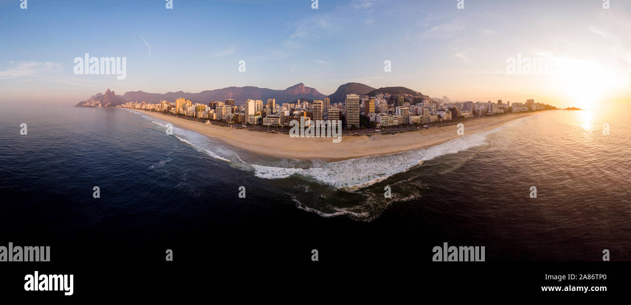 Beautiful summer sunrise in the marvellous city of Rio de Janeiro with waves arriving on the early morning empty beaches of Ipanema and Leblon Stock Photo