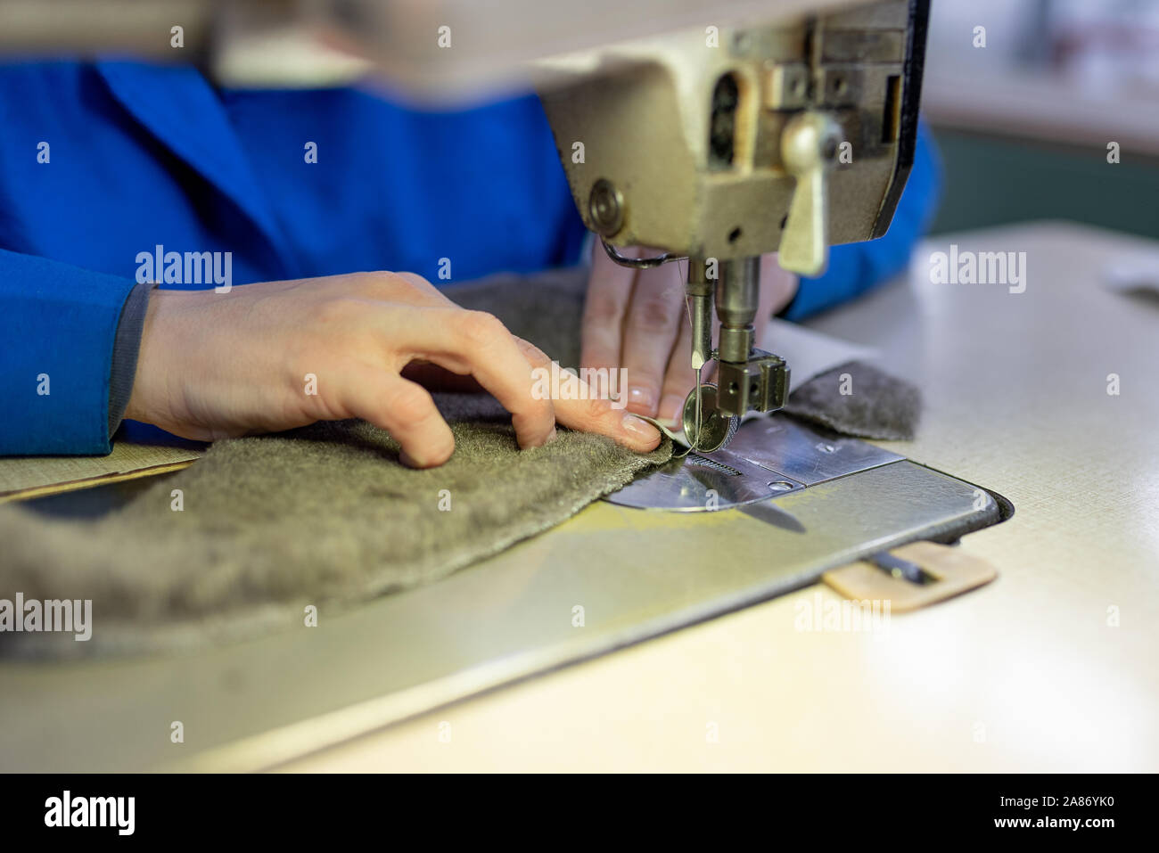 Sewing details of fur and leather. Shoe production. Stock Photo