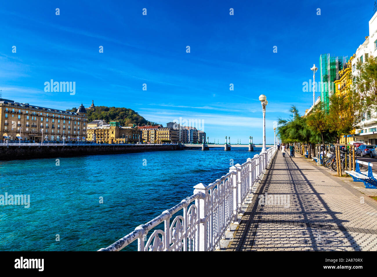 Pedastrian promenade by the Urumea river with view of the old town, Zurriola bridge and Urgul hill, Ramón María Lili Pasealekua, San Sebastian, Spain Stock Photo