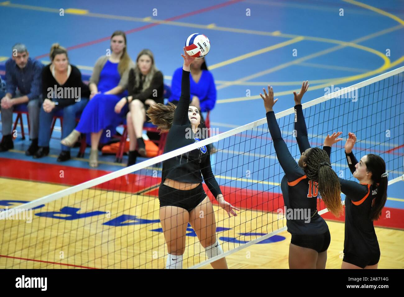 Player attempting to deliver a kill shot past two opponents about to  try to block the effort.  USA. Stock Photo